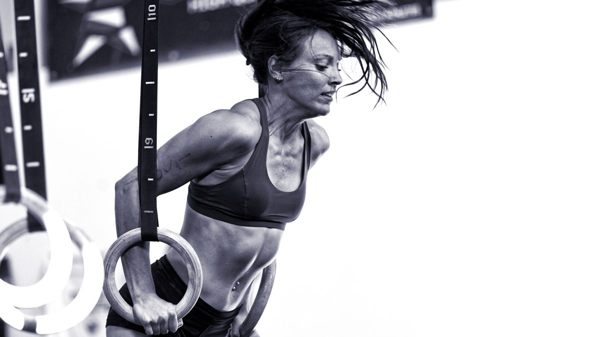 Female CrossFit athlete does a muscle up