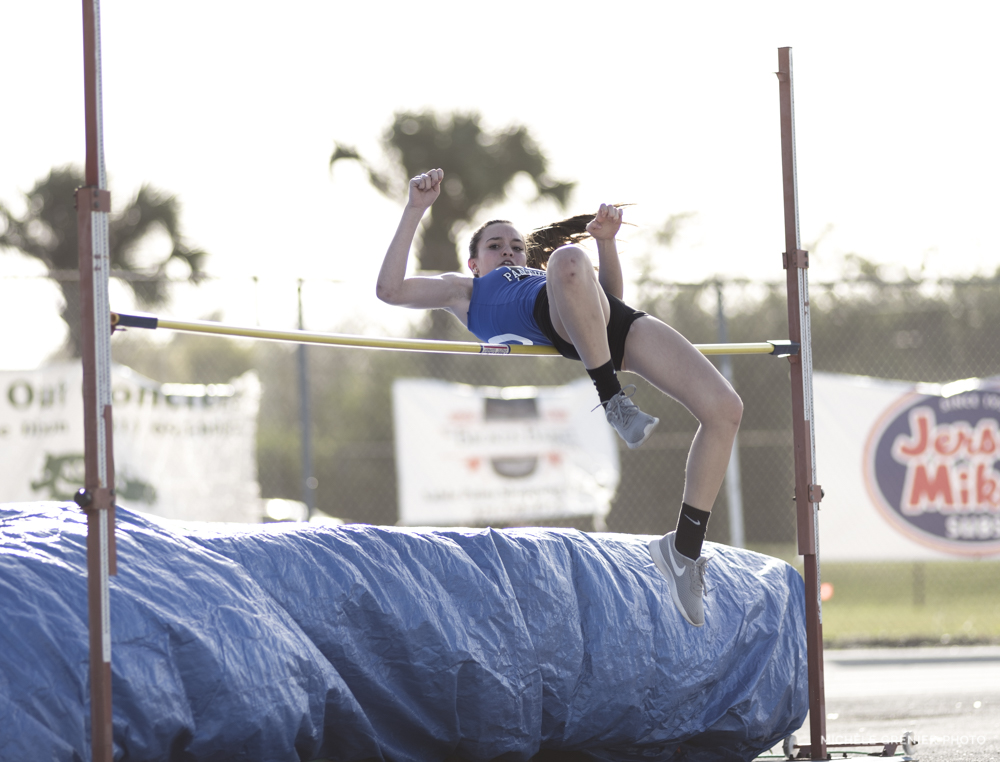 Athlète de sport féminine d'athlétisme qui fait réussi un saut en hauteur prise en photo