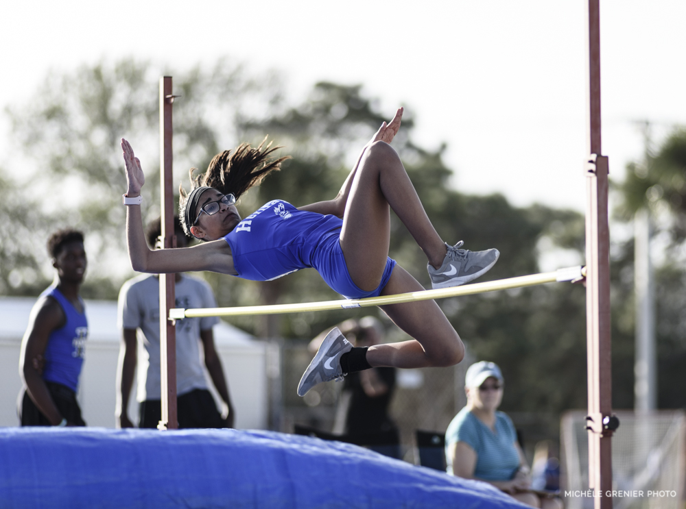 Athlète de sport féminine d'athlétisme qui fait réussit un saut en hauteur prise en photo