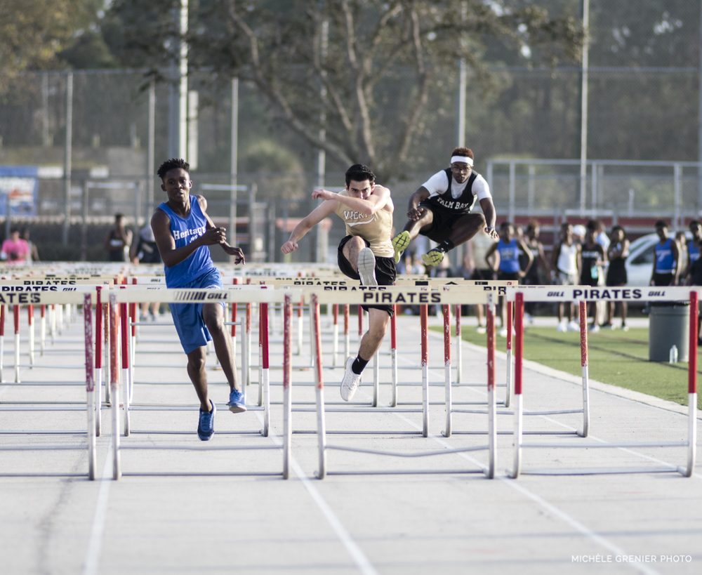 Athlètes de sport masculin d'athlétisme qui font des sauts réussis par-dessus des haies lors d'une compétition