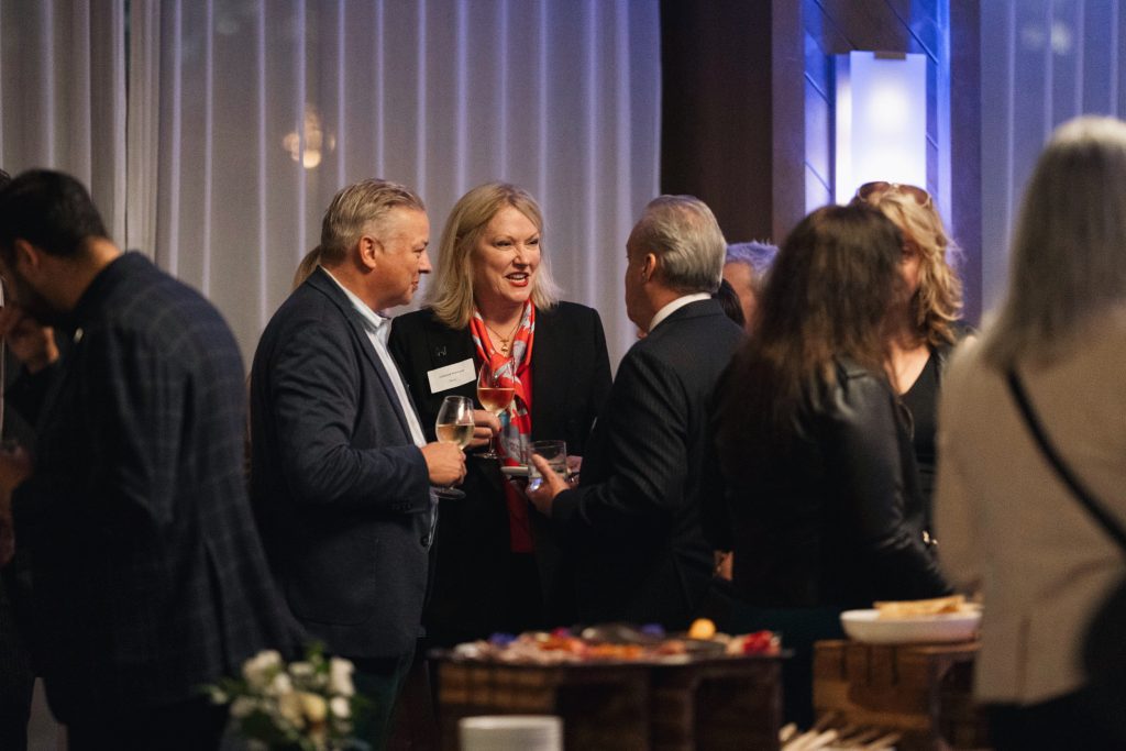 Trois professionnels en pleine conversation lors d'un cocktail