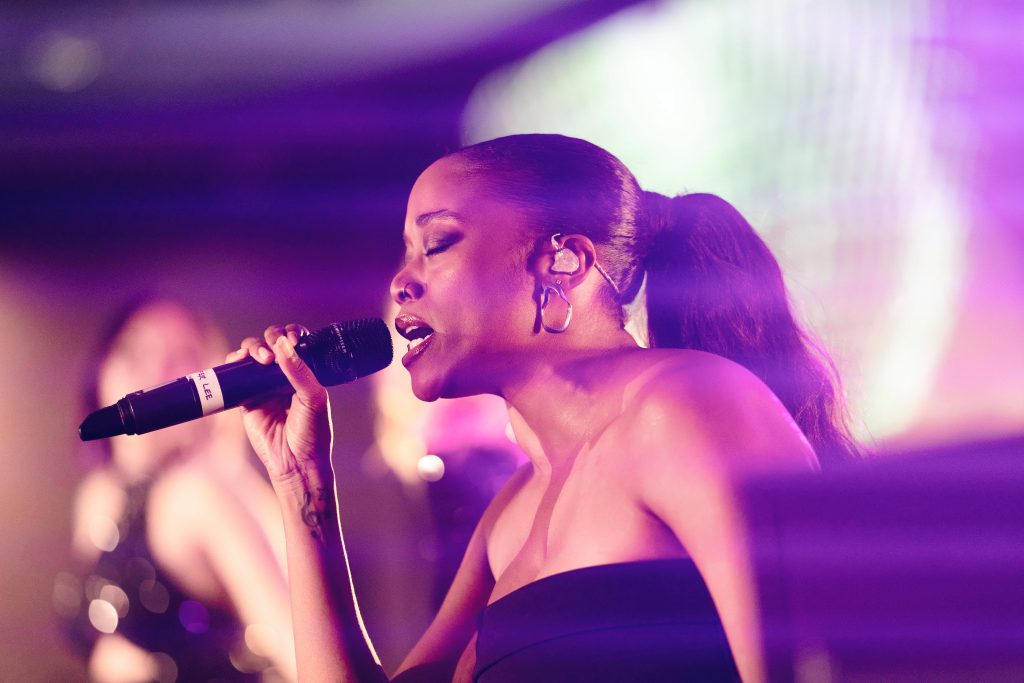 Female singer at a cocktail event with purple light